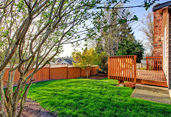 Spacious wooden patio deck with yellow chairs and a scenic fence view in Inglewood.